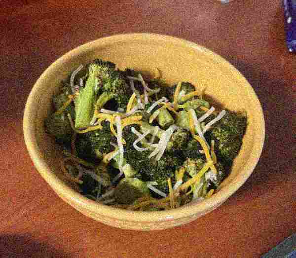 A yummy-looking bowl of
      broccoli with cheese. The image is very compressed.